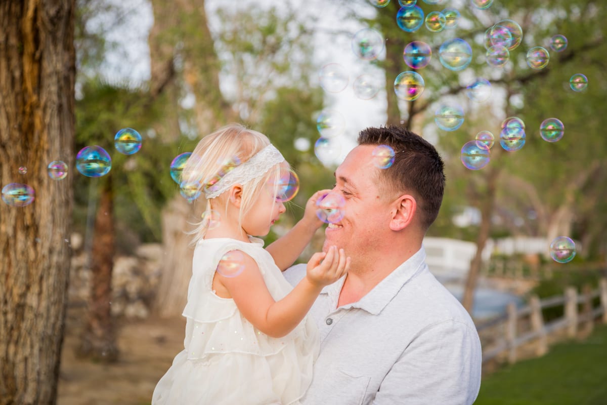 Hire bubble machine — affectionate father holding cute baby girl enjoyin for parties and events in Johannesburg, Sandton and Randburg
