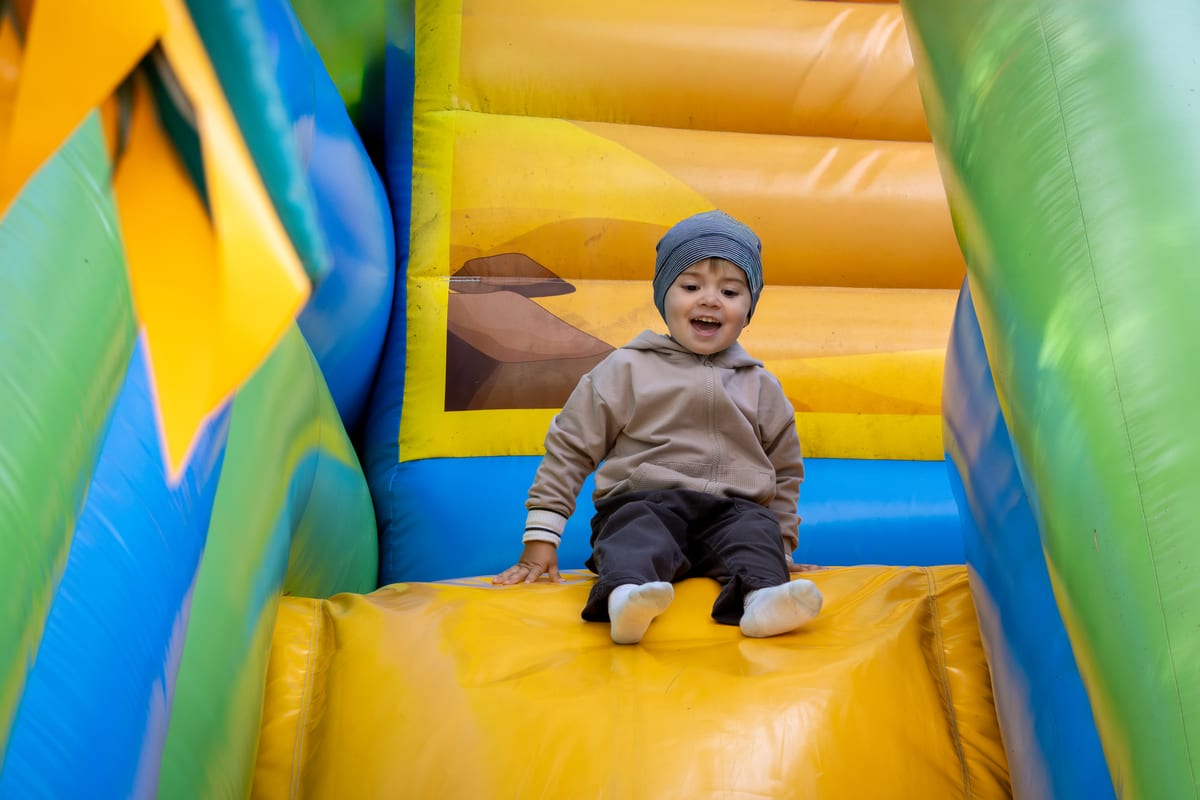 Jumping Castle hire — happy toddler on a colorful inflatable slide | Panda Party Hire Hire jumping castle — happy toddler on a colorful inflatable slide for parties and events in Johannesburg, Sandton and Randburg