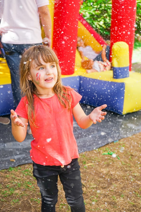 Jumping Castle hire — girl playing with bubbles in front of bouncy house | Panda Party Hire Hire jumping castle — girl playing with bubbles in front of bouncy house for parties and events in Johannesburg, Sandton and Randburg