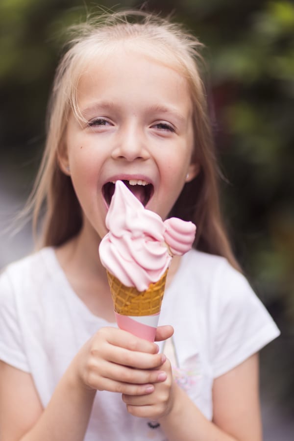 Soft Serve Machine hire — happy girl eating pink ice cream cone outdoors | Panda Party Hire Hire soft serve machine — happy girl eating pink ice cream cone outdoors for parties and events in Johannesburg, Sandton and Randburg