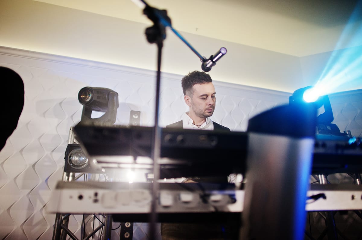 Sound System hire — musician plays keyboard on stage under blue lights | Panda Party Hire Hire sound system — musician plays keyboard on stage under blue lights for parties and events in Johannesburg, Sandton and Randburg